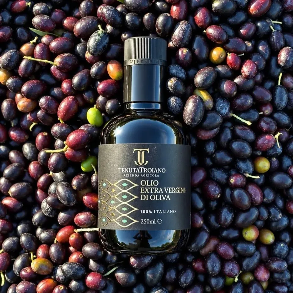 Bottiglia da 250 ml Tenuta Troiano tra olive scure.