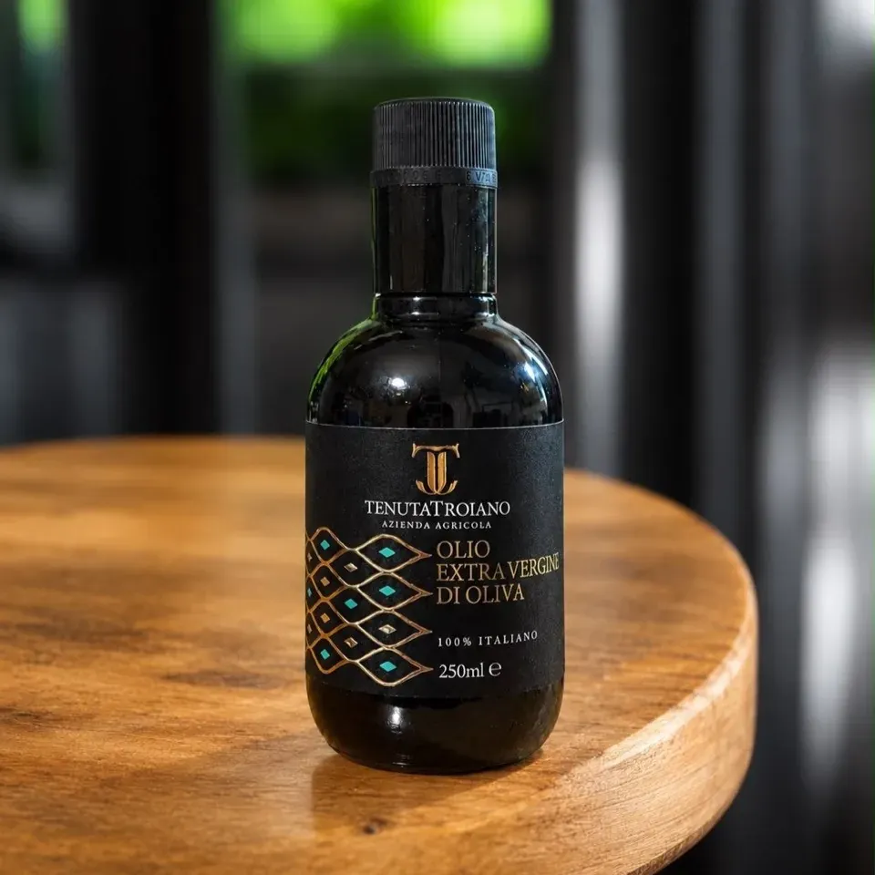 Bottiglia da 250 ml Tenuta Troiano su un tavolo di legno.
