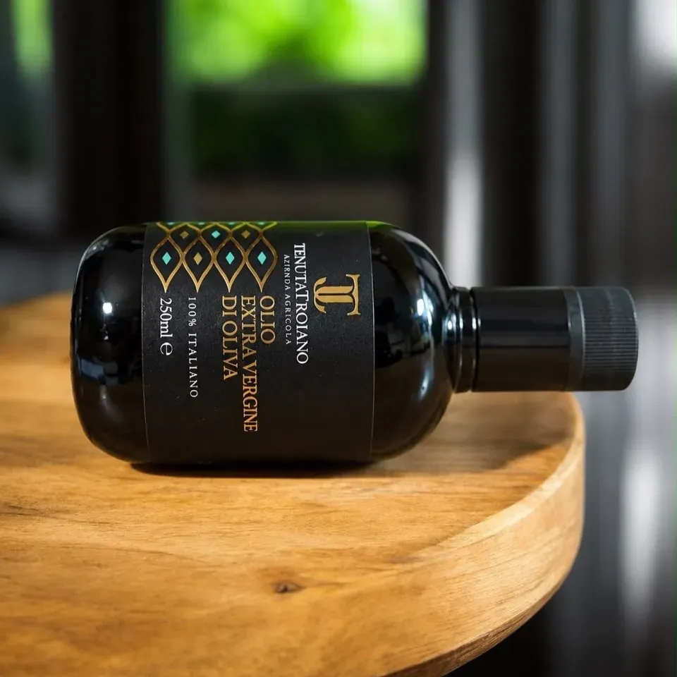 Bottiglia da 250 ml Tenuta Troiano distesa su un tavolo di legno.