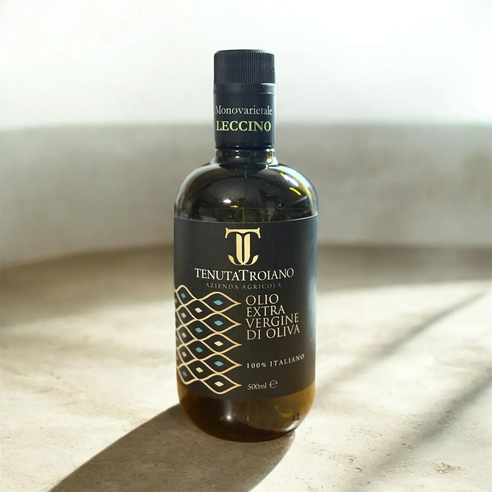 Bottiglia da 500 ml Tenuta Troiano in piedi su un piano chiaro.